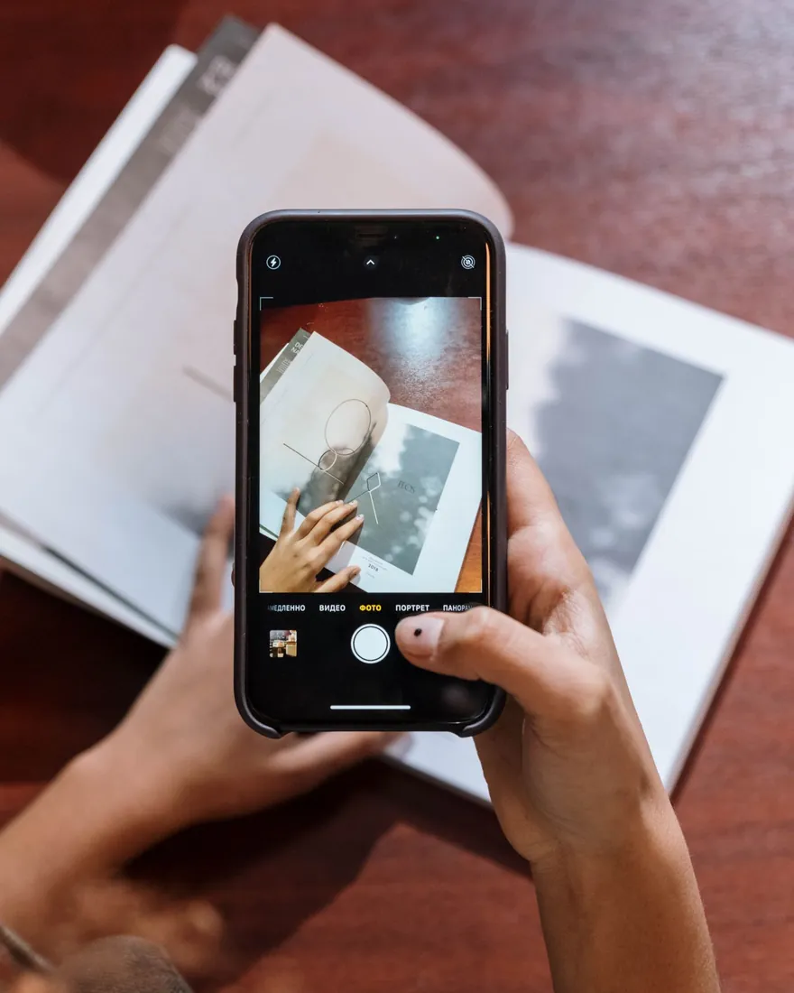 A reader photographing a book cover with a phone to check its certificate